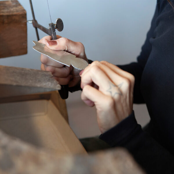 Form wird aus einem Stück Silber ausgesägt